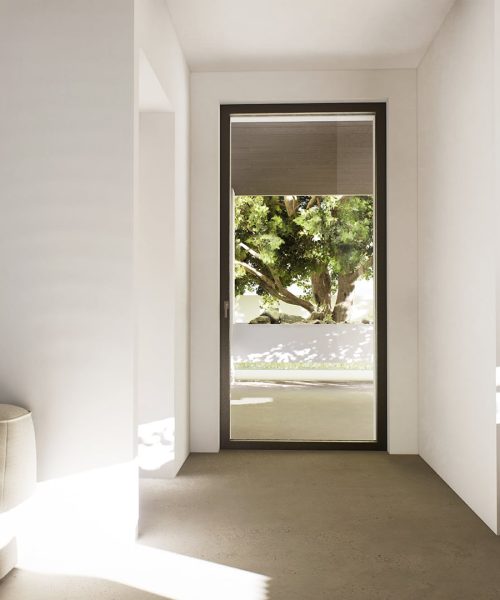 Porta finestra con telaio minimale in alluminio, che illumina una stanza moderna con una vista sul giardino.
