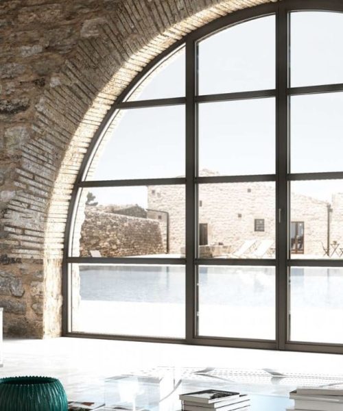 Finestra ad arco in alluminio con taglio termico in ambiente rustico moderno